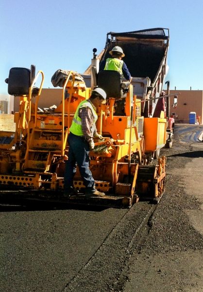 Crew laying fresh asphalt on a paving job